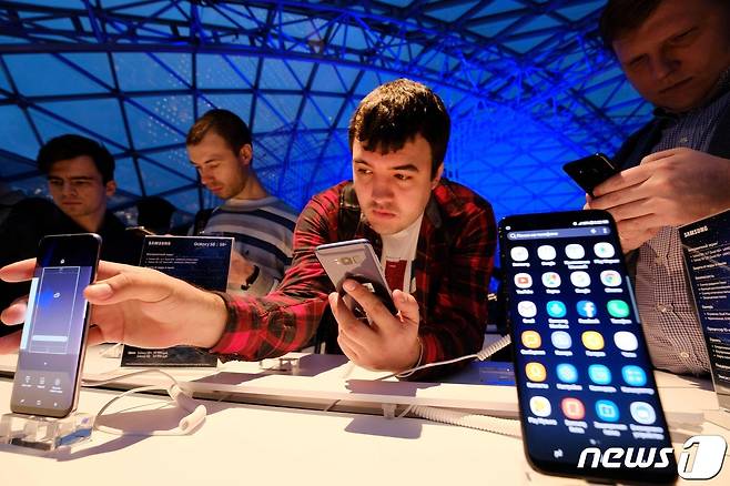 러시아 수도 모스크바의 한 전자제품 상점에서 남성들이 삼성 스마트폰 갤럭시 S8를 살펴보고 있다. 2017.04.13 ⓒ AFP=뉴스1 ⓒ News1 정윤미 기자