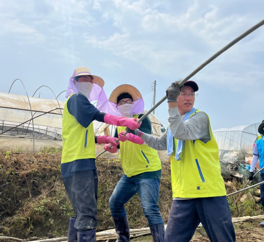 지난달 31일 충남 부여군 장암면에서 금융지주 봉사단, 농협 충남본부 부여군지부, 농협 대전본부 직원 등 40여 명이 함께 집중호우 피해 농가를 찾아 일손 돕기에 나섰다. 김익수 NH농협금융지주 경영기획부문 부사장(오른쪽)과 봉사단원들이 수해 피해 농가에서 복구 작업을 하고 있다. 농협금융 제공.