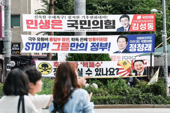 31일 서울 마포구 합정역 인근에 각 정당 현수막이 난립하고 있다. 위쪽부터 김성동 국민의힘 마포을 당협위원장, 정청래 민주당 의원, 열린민주당이 붙인 현수막 모습. 정의당 마포을 지역위원장인 장혜영 의원이 붙인 현수막(오른쪽 맨 아래)은 한쪽 끈이 풀린채 떨어져있다. 김경록 기자