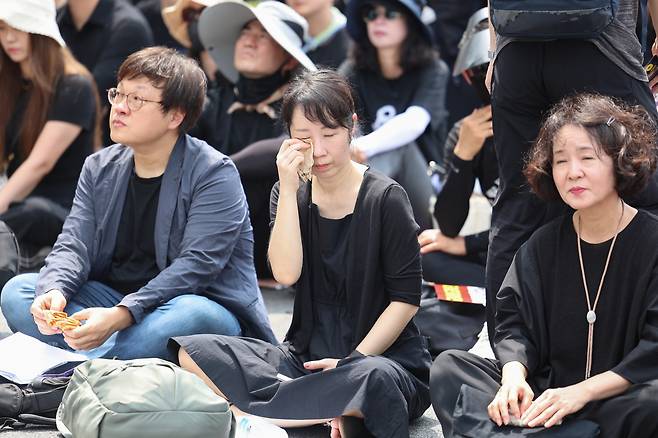 29일 서울 종로구 경복궁역 사거리 인근에서 열린 공교육 정상화를 위한 집회에서 한 참가자가 고인이 된 서이초 담임교사를 위한 추모영상을 보며 눈시울을 붉히고 있다. [연합]