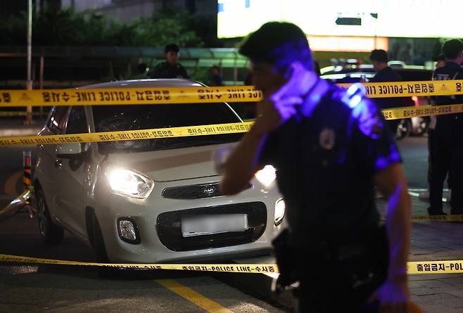 A police officer stands in front of a police line marking off the car that injured at least four people near Seohyeon Station in Bundang, Gyeonggi Province, Thursday. (Yonhap)