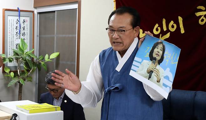 3일 용산 대한노인회 중앙회에서 김호일 회장이 노인폄하 발언 사과를 위해 방문한 더불어민주당 김은경 혁신위원장과 면담 중 위원장의 뺨 대신 사진을 때리고 있다. [연합]