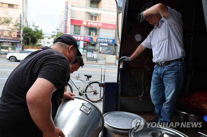 "아휴 어지러워" (대전=연합뉴스) 강수환 기자 = 지난 2일 오후 대전역 광장에서 무료급식소를 운영하는 대전 동구 벧엘의집에서 직원들이 트럭에 음식을 싣고 있다. 더운 날씨에 이날 한 직원은 어지럼증을 잠시 호소하기도 했다. 2023.8.3 swan@yna.co.kr