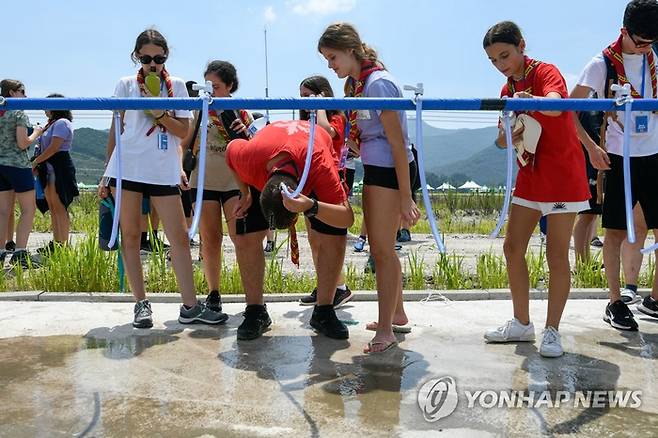2023 새만금 세계잼버리에 참가한 스카우트 대원들이 지난 1일 수돗가에서 물을 적시며 더위를 식히고 있다. [사진 = 연합뉴스]