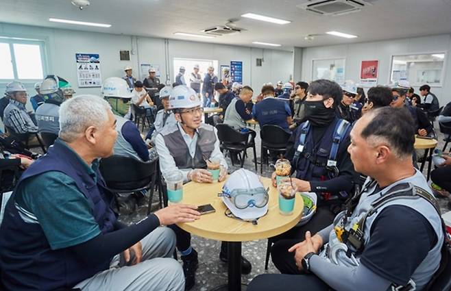 김승모 대표이사가 지난 3일 인천공항 제2터미널 확장공사 현장 내 휴게실을 찾아 폭염을 피해 휴식을 취하고 있는 근로자들과 대화를 나누고 있다. [사진 = 한화 건설부문]