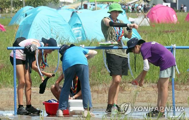 수돗가의 잼버리 대원들 (부안=연합뉴스) 최영수 기자 = 2023 새만금 세계스카우트잼버리 참가자들이 4일 전북 부안군 잼벼리 야영장 수돗가에서 물을 받거나 옷을 적시고 있다. 2023.8.4 kan@yna.co.kr