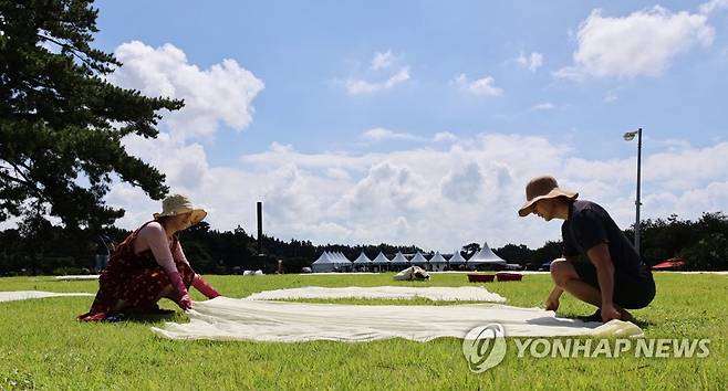 제주 전통 염색 체험 (서귀포=연합뉴스) 변지철 기자 = 5일 제주 서귀포시 남원읍 하례리 서귀포농업기술센터에서 열린 '2023 천연염색 페스티벌'에서 참가자들이 염색한 의류 등을 햇볕에 말리고 있다. 2023.8.5 bjc@yna.co.kr