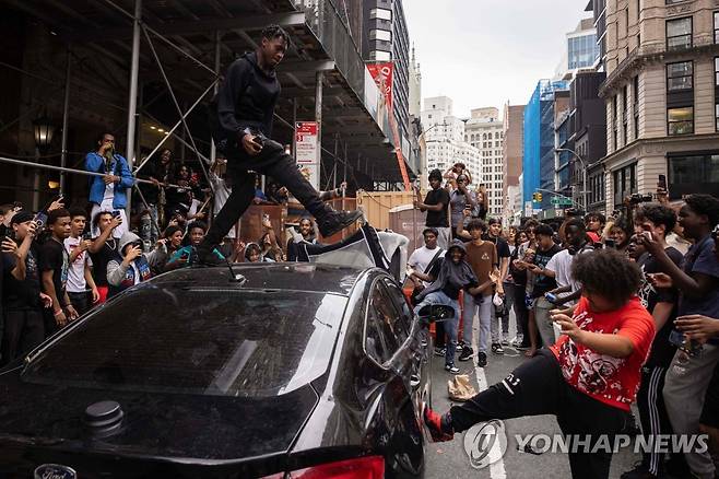 뉴욕 맨해튼 유니언스퀘어 주변에서 공격받는 차량 (뉴욕 AFP=연합뉴스) 공짜 선물을 받기 위해 맨해튼 유니언스퀘어에 모인 청소년들이 주변을 지나는 자동차를 공격하고 있다. 2023.8.5 photo@yna.co.kr