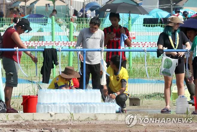 잼버리장 수돗가의 생수 (부안=연합뉴스) 최영수 기자 =  2023 새만금 세계스카우트잼버리 참가자들이 6일 야영장 수돗가에서 물을 받고 있다. 지원된 생수도 보인다. 2023.8.6 kan@yna.co.kr