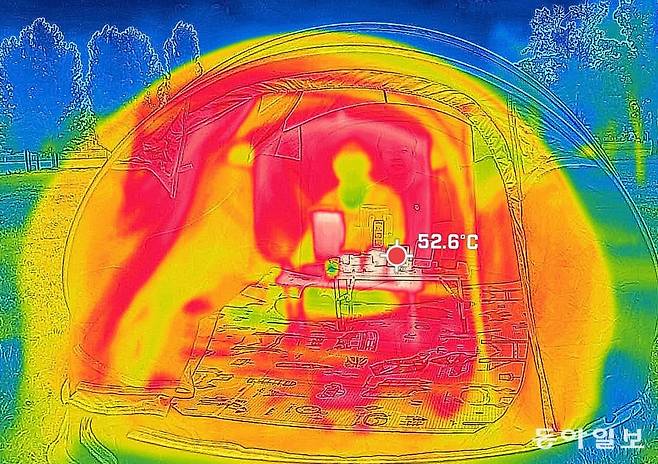 낮 최고기온이 35도를 기록한 3일 서울 여의도 한강공원에서 동아일보 기자가 땡볕 텐트 체험을 하고 있다. 열화상 카메라에 찍힌 텐트 내부 온도는 50도가 넘었다. 이한결 기자 always@donga.com