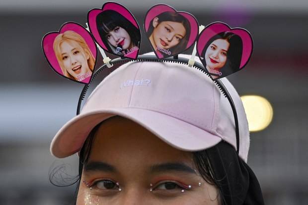 인도네시아 K팝 팬이 지난 3월 12일 자카르타에서 열린 공연을 앞두고 블랙핑크 멤버들의 얼굴을 활용한 밴드를 착용하고 있다. 자카르타=AFP연합뉴스