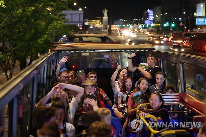 서울 온 잼버리 영국 대원들, 첫 일정은 시티투어버스 (서울=연합뉴스) 류영석 기자 = 2023 새만금 세계 스카우트 잼버리에서 조기 퇴영한 영국 스카우트 대원들이 6일 밤 광화문 서울 시티투어버스에 탑승해 출발 전 환호하고 있다.2023.8.6 ondol@yna.co.kr