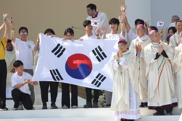 포르투갈 리스본의 테주 공원에서 열린 올해 가톨릭 세계청년대회 폐막 미사에서 2027년 차기 대회 개최지가 서울로 발표되자 한국의 순례자들과 주교들이 무대 위에서 태극기를 펼쳐 들며 환호하고 있다. 연합뉴스