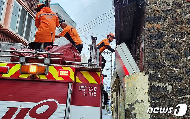 제6호 태풍 '카눈(KHANUN)'이 북상 중인 9일 오후 1시52분쯤 제주시 구좌읍 세화리의 한 건물에서 간판이 떨어져 소방대원들이 안전조치를 취하고 있다.(제주특별자치도 소방안전본부 제공)2023.8.9/뉴스1 ⓒ News1 오미란 기자