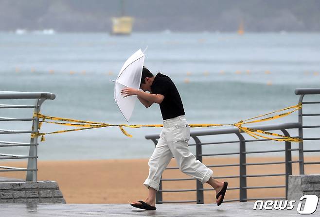 제6호 태풍 '카눈'이 북상 중인 9일 부산 해운대구 엘시티 인근에 강한 빌딩풍이 몰아쳐 한 시민이 우산을 부여 잡고 힘겹게 걷고 있다. 2023.8.9/뉴스1 ⓒ News1 윤일지 기자