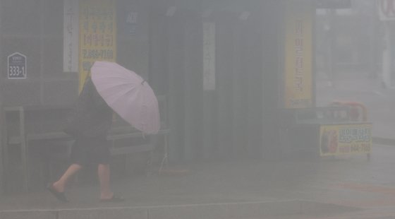 10일 오전 경남 통영시 강구안 주변에서 우산을 쓴 시민이 걸어가고 있다.   통영지역은 제6호 태풍 '카눈'의 상륙 길목으로 예보된 곳이다. 연합뉴스