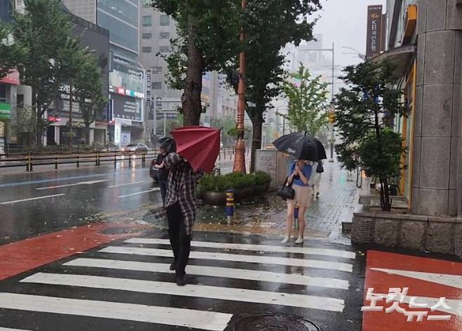 제 6호 태풍 '카눈'이 상륙한 10일 오전 9시쯤 부산 연제구에서 시민들이 비바람을 맞으며 길을 걷고 있다.  정혜린 기자