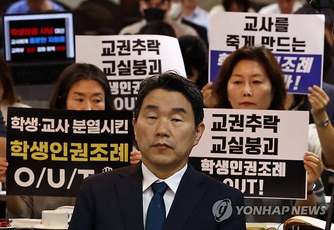 교권 보호 강화 방안 관련 교육개혁 대토론회 (서울=연합뉴스) 윤동진 기자 = 10일 오전 서울 코리아나호텔에서 열린 ‘교권 회복 및 보호를 위한 교육부-국가교육위원회 공동주최 토론회’에서 서울교육사랑학부모연합 등 단체가 학생인권조례 폐지를 촉구하는 피켓을 들고 있다. 앞은 이주호 부총리 겸 교육부 장관. 2023.8.10 mon@yna.co.kr