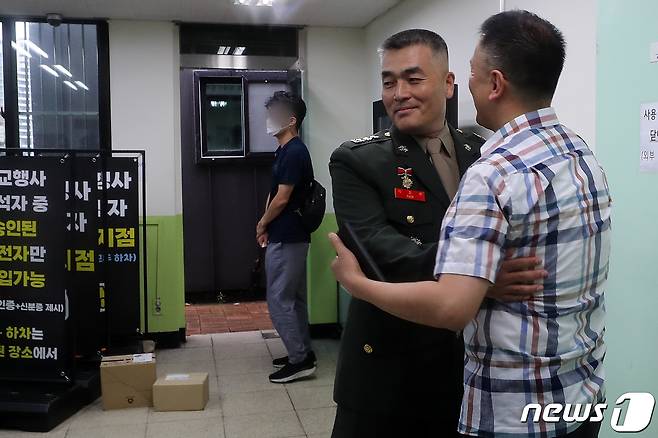 지난달 집중호우 피해 실종자 수색작전 중 순직한 고(故) 채수근 상병 사고 조사결과 보고서를 경찰에 이첩했던 박정훈 전 해병대 수사단장(대령)이 11일 오전 용산구 국방부 소재 국방부 검찰단 출석에 앞서 김태성 해병대 사관 81기 동기회 회장으로 부터 응원을 받고 있다. 2023.8.11/뉴스1 ⓒ News1 이동해 기자