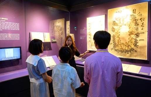 독도체험관 고길정(뒷줄 가운데) 해설사가 소중 학생기자단에게 독도가 우리 땅인 역사적 이유를 담은 사료들을 소개했다.