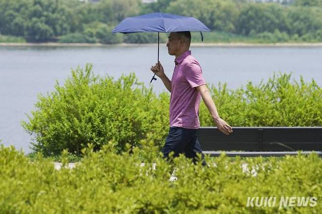 지난 6월 서울 영등포구 여의도 한강시민공원 인근에서 양산을 쓴 시민이 이동하고 있다. &nbsp; 사진=임형택 기자