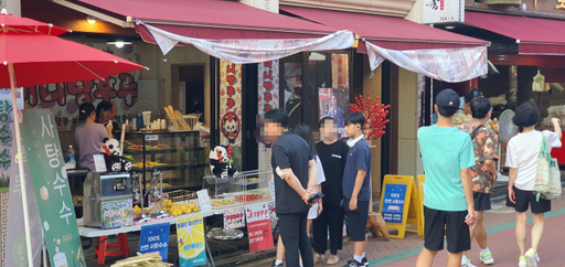 13일 오후 가족 단위의 중국 관광객들이 ‘탕후루’ 전문점에서 주문할 음식을 살펴보고 있다. 지우현기자