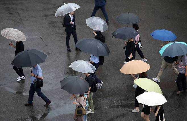 6호 태풍 카눈이 소멸된 지난 11일 오전 서울 중구 서울역 인근에서 시민들이 우산을 쓰고 이동하고 있다. /사진=뉴시스