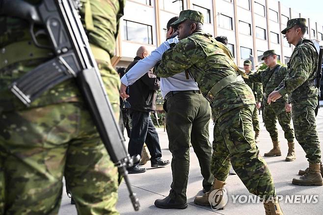 선관위 직원 몸 수색하는 에콰도르 군 장병 (키토 AFP=연합뉴스) 에콰도르 대선을 일주일 앞둔 13일(현지시간) 키토 살레시아나 대학교 앞에서 군 장병이 투표 절차 점검을 위해 현장을 찾은 선관위 직원을 상대로 몸 수색을 하고 있다. 2023.8.14