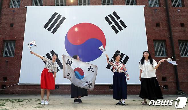 제78주년 광복절을 맞은 15일 서울 서대문형무소역사관의 대형 태극기 앞에서 시민들이 태극기를 힘차게 흔들고 있다. 2023.8.15/뉴스1 ⓒ News1 이동해 기자