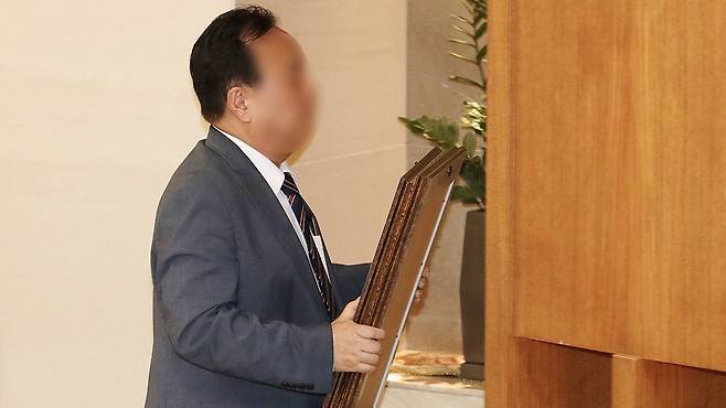 윤석열 대통령의 부친 윤기중 연세대 명예교수 빈소가 마련되는 서울의 한 병원 장례식장에서 관계자가 윤 교수의 영정 사진을 옮기고 있다. 뉴스1