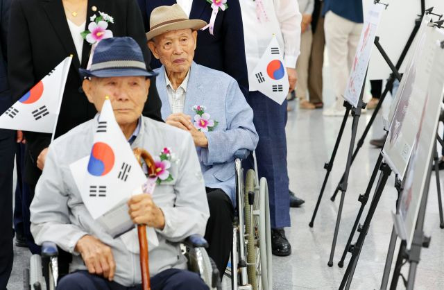 일제강제 징용 피해자 이춘식(앞)·이경석 할아버지가 15일 오전 광주시청 1층 로비에서 열린 일제강제 징용 피해자 구술 사진전을 관람하고 있다. 연합뉴스