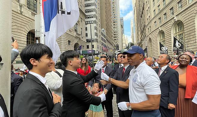 에릭 애덤스 미국 뉴욕시장(오른쪽)이 14일(현지시간) 뉴욕 월스트리트의 ‘돌진하는 황소상’ 앞에서 브라이언 전 재미차세대협의회 회장과 함께 태극기를 게양하고 있다. 뉴욕=연합뉴스