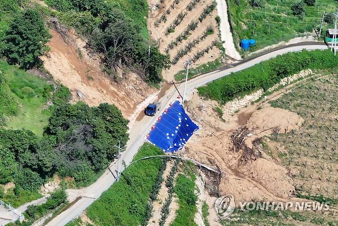 겨우 복구된 도로 (예천=연합뉴스) 윤관식 기자 = 15일 경북 예천군 효자면 백석리에서 지난달 산사태로 유실됐던 도로가 응급 복구돼 통행이 가능한 모습을 보이고 있다. 2023.8.15 psik@yna.co.kr