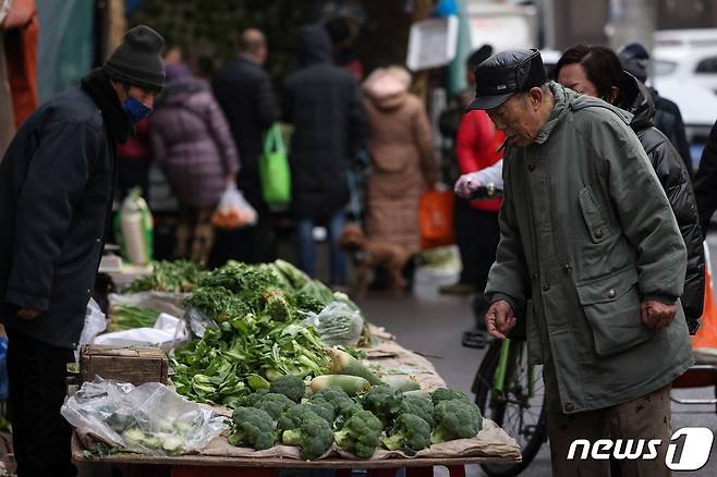 중국 북동부 랴오닝성 선양의 한 재래시장에서 손님들이 채소를 살펴보고 있고 있다. 2023.2.10 ⓒ AFP=뉴스1