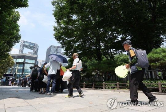 폭염 경보가 발효 중인 8월 1일 서울 종로구 탑골공원에서 어르신들이 햇볕을 피해 무료급식을 기다리고 있다.<사진: 연합뉴스>