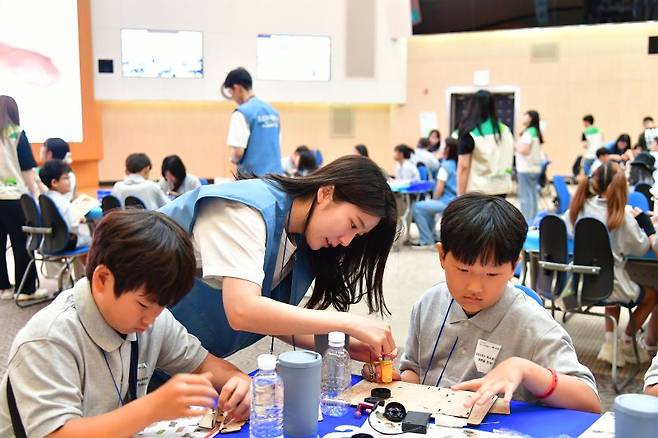 16일 '푸른꿈 환경학교'에서 포스코퓨처엠 직원이 어린이들과 함께 전기차 모형을 제작하고 있다. 포스코퓨처엠 제공