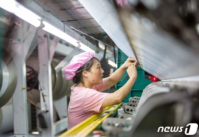 중국 동부 장쑤성 하이안시의 한 섬유 공장에서 한 근로자가 일하고 있다.2023.8.16 ⓒ AFP=뉴스1