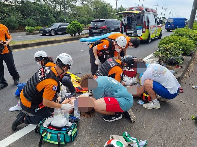 17일 낮 12시 36분쯤 제주 서귀포시 대정읍 한 도로에서 독일 국적 잼버리 대원 A양이 몰던 오토바이가 도로 연석을 들이받고 쓰러져 A양과 동승자인 쌍둥이 B양이 중경상을 입고 119구급대가 긴급 구조활동을 벌이고 있다. 제주도 소방안전본부 제공