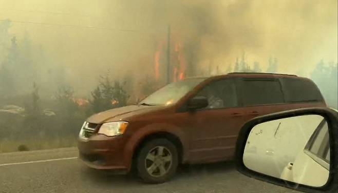 16일(현지시간) 캐나다 노스웨스트 준주 옐로나이프에 주민 대피령이 내려진 가운데,  도시를 빠져나가는 고속도로가 불길과 연기에 휩싸여 있다. AFP연합뉴스