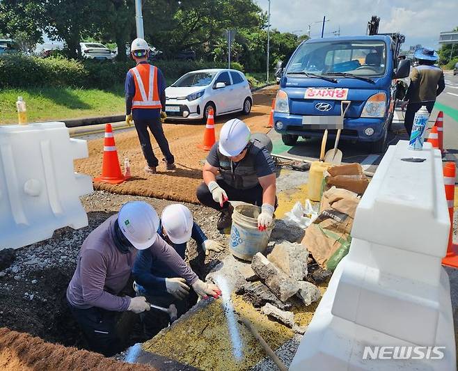 [제주=뉴시스] 오영재 기자 = 18일 오전 제주국제공항 입구 교차로에서 '땅 꺼짐' 현상이 발생해 제주시와 제주도자치경찰단이 긴급 복구 작업에 나서고 있다. 2023.08.18. oyj4343@newsis.com