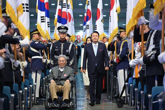 윤석열 대통령이 15일 서울 서대문구 이화여대 대강당에서 열린 제78주년 광복절 경축식에서 오성규 애국지사와 함께 입장하고 있다. 뉴스1