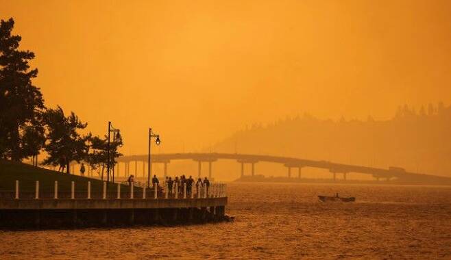 18일(현지시각) 캐나다 브리티시컬럼비아주 킬로나의 오카나간 호수 지역이 맥도걸 크리크 화재로 발생한 연기로 붉게 물들어 있다.ⓒAP/뉴시스