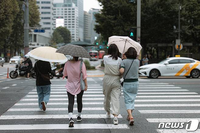 소나기가 내리는 21일 오후 서울 종로구 종각역 사거리에서 우산을 쓴 시민들이 발걸음을 재촉하고 있다. 2023.8.21/뉴스1 ⓒ News1 이재명 기자