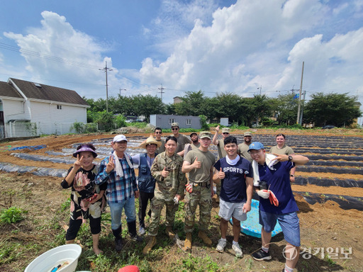 21일 평택 팽성읍 동창리 일원에서 팽성읍 길위의교회 관계자와 주한미군이 배추를 심은 뒤 기념사진을 촬영하고 있다. 안노연기자