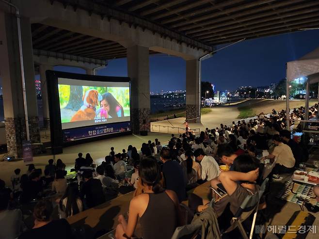 20일 밤 서울 여의도한강공원 원효대교 남단에서 ‘한강물빛영화관’의 영화 ‘안녕 베일리’가 상영되고 있다. 김용재 기자