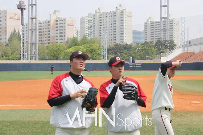 지난해 덕수고 동료인 심준석(사진 좌)과 이야기를 나누는 김진혁(사진 우). 부상 후 유급을 선택한 김진혁은 재활 후 첫 선발 경기에서 5이닝 무실점투를 선보였다. 사진ⓒ김현희 기자