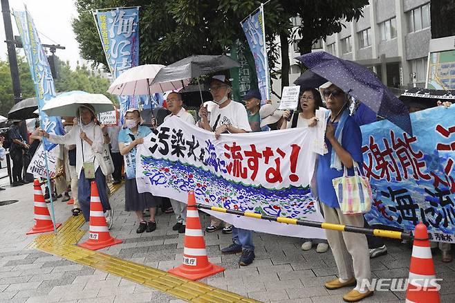 [도쿄=AP/뉴시스]22일 오전 도쿄 총리 관저 앞에서 후쿠시마 제1 원자력발전소 오염수 해양 방류에 반대하는 시위가 열렸다. 비가 오는 가운데 시위대가 '오염수를 바다에 흘려보내지 말라'는 현수막을 들고 구호를 외치고 있다. 2023.08.22.