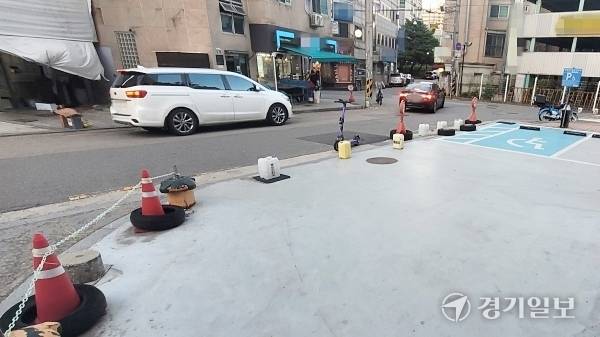 수원특례시 장안구의 한 상가 앞 장애인 전용 주차구역에 진입을 막는 물통과 표지판이 놓여 있다. 김건주기자