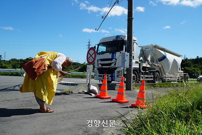 ‘더 이상 바다를 더럽히지 마라 시민회의’ 소속 일본 활동가들이 24일 후쿠시마 원전 인근에서 오염수 방류 반대 시위를 하고 있다. 한 스님이 출입이 통제된 도로 끝에서 목탁을 두드리며 오염수 방류 중단을 촉구하고 있다.  후쿠시마 | 이윤정 기자