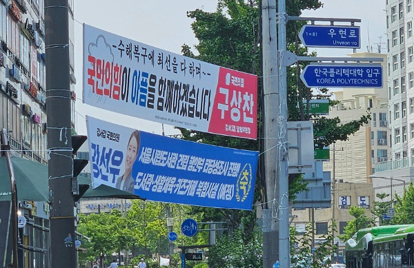 지난 1일 서울 강서구 우장산역 사거리 전봇대와 신호등 기둥에 국민의힘과 더불어민주당의 현수막이 위아래로 걸려 있다. 박성영 기자